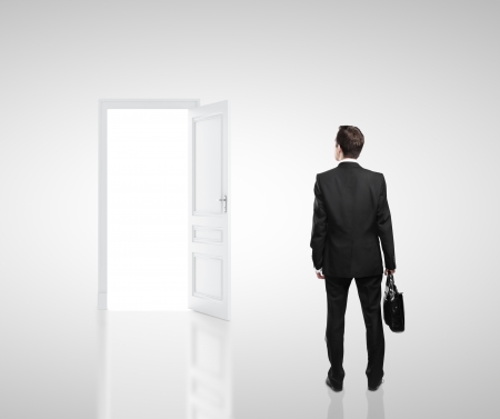 businessman in white room with doors openの写真素材