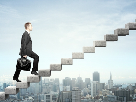 Businessman stepping up a staircase and city