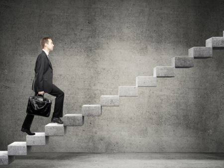 Businessman stepping up a staircaseの写真素材