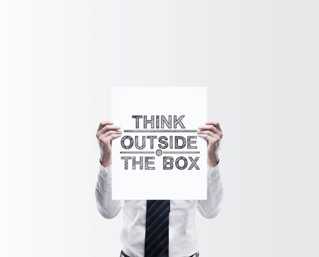 businessman holding poster with think outside the boxの写真素材