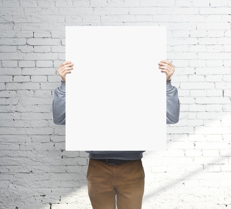 man holding white blank posterの写真素材