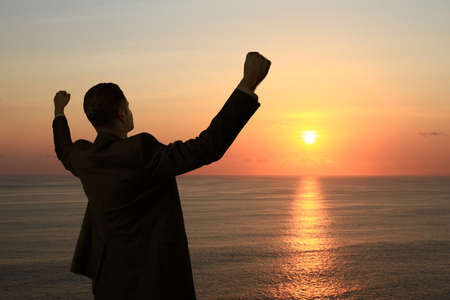 happy man standing  on background of sunsetの写真素材