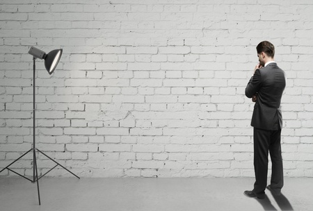 businessman on brick room and spotlightの写真素材