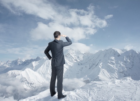 businessman looking to winter mountainsの写真素材