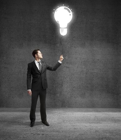 businessman standing on concrete room with drawing lampの写真素材