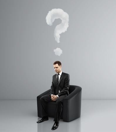 businessman sitting in sofa and question markの写真素材