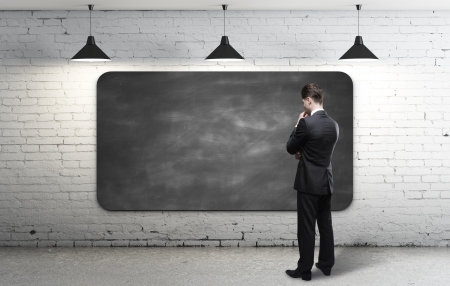 businessman looking at blackboard in loft interiorの写真素材