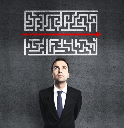 businessman looking at maze with red arrowの写真素材