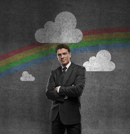 man with hands in pocket and rainbow on wallの写真素材