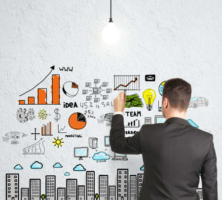 businessman drawing strategy on concrete wallの写真素材