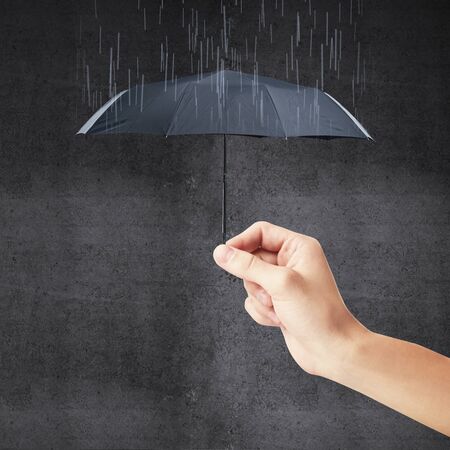 hand holding a small umbrella and rainの写真素材