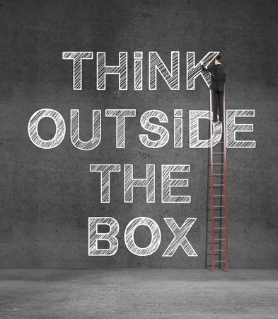 businnessman drawing think outside the box concept in concrete wallの写真素材