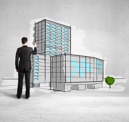 man drawing skyscraper on concrete wallの写真素材