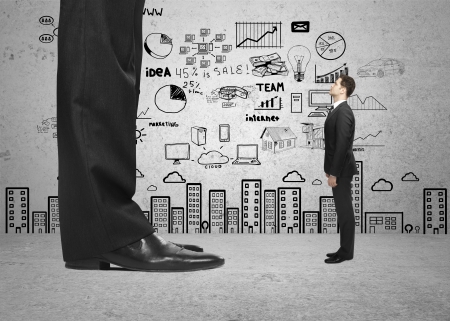 big foot and small businessman and strategy on wallの写真素材