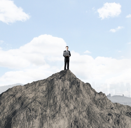 businessman with laptop standing onmountinの写真素材