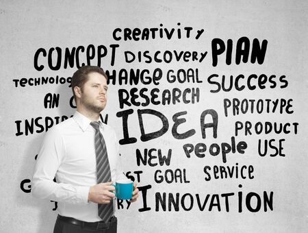 man with cup of coffe and drawing tagsの写真素材