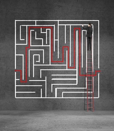 man climbing on ladder drawing mazeの写真素材