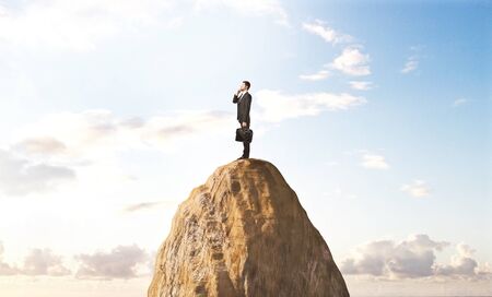 businessman standing  on peak mountinの写真素材