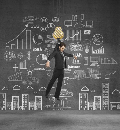 hook holding businessman on concrete backgroundの写真素材