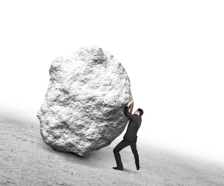 businessman pushing stone up hillの写真素材