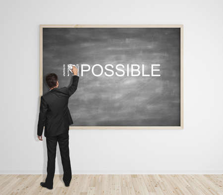 businssman erases the impossible on blackboard