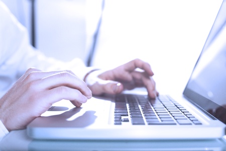 hands pushing keys of laptopの写真素材