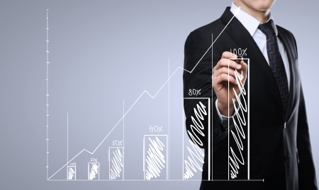 businessman drawing graph on a blue backgroundの写真素材