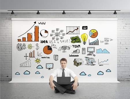 businessman sitting in lotus with laptop and business strategy on posterの写真素材