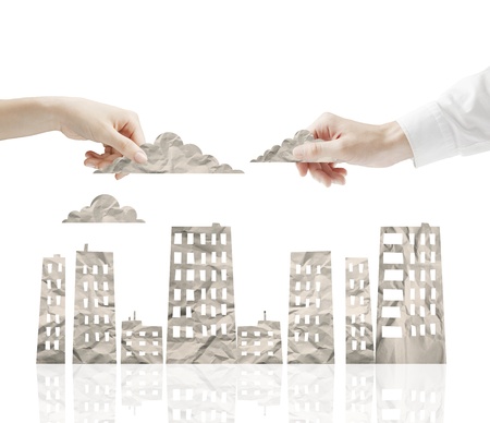 hands holding cloud over paper cityの写真素材