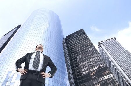 businessman standing in city and looking upの写真素材