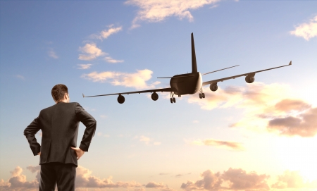 businessman standing and looking on  airplaneの写真素材