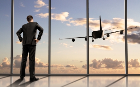 businessman in airport looking on airplane in skyの写真素材