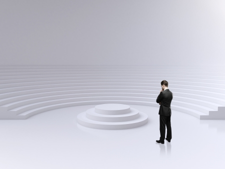 businessman standing and lookig on a podium in circle auditoriumの写真素材