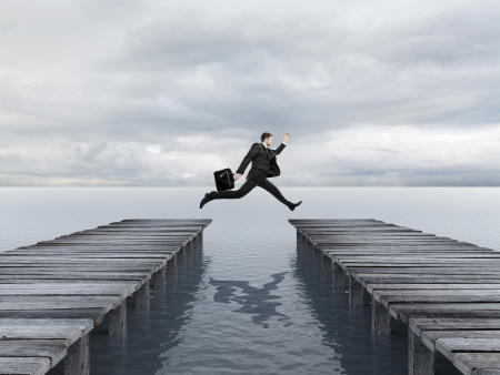 businessman jumping from one pier  to anotherの写真素材