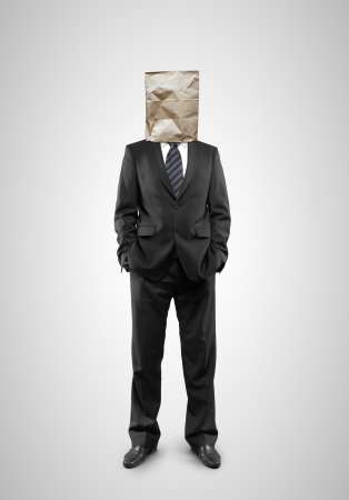 businessman standing with paper bag on headの写真素材