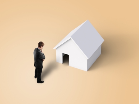 man looking at toy houseの写真素材