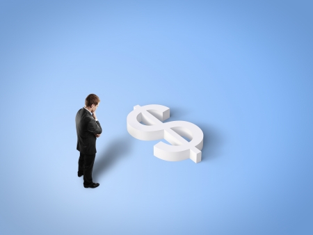 businessman looking at toy dollar signの写真素材