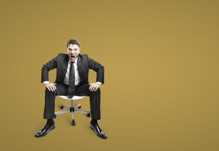 businessman sitting on chair and screamingの写真素材