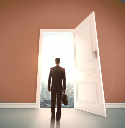 businessman with briefcase open door to cityの写真素材