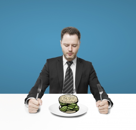 businessman sitting and eating hamburger moneyの写真素材
