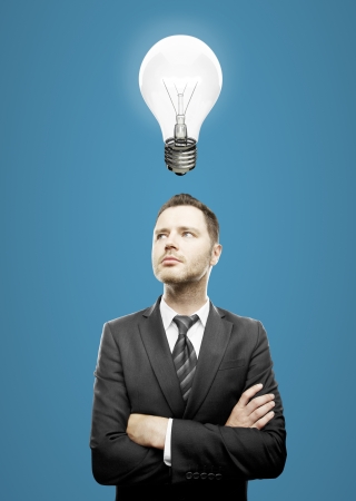 businessman standing and folded his hands  and lamp over headの写真素材