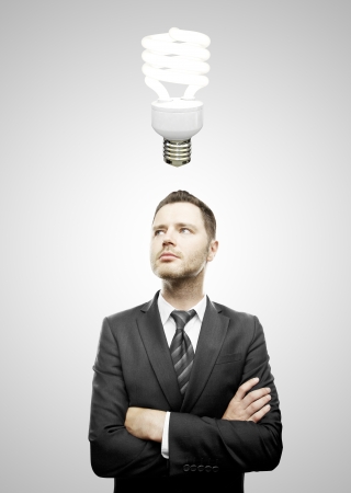 businessman and folded his hands  and energy-saving lamp over headの写真素材