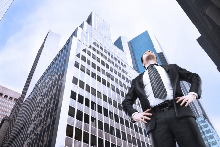 businessman standing in city and looking upの写真素材
