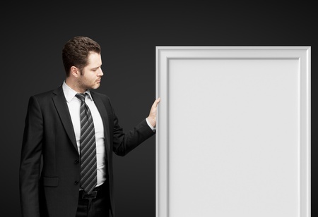 businessman holding frame on a black backgroundの写真素材