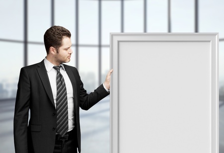 businessman holding blank frame in officeの写真素材