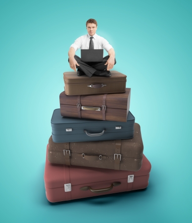 businessman sitting on travel bagsの写真素材