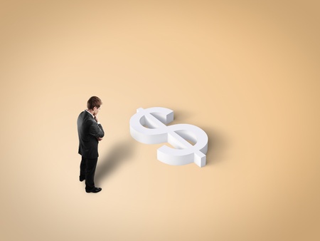 businessman looking at toy dollar signの写真素材