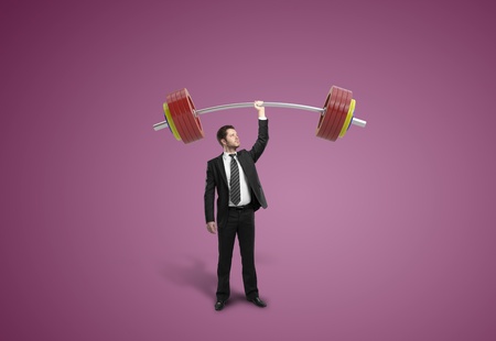businessman holding barbell on pink backgroundの写真素材