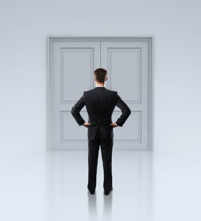 businessman standing in front of closed doorsの写真素材
