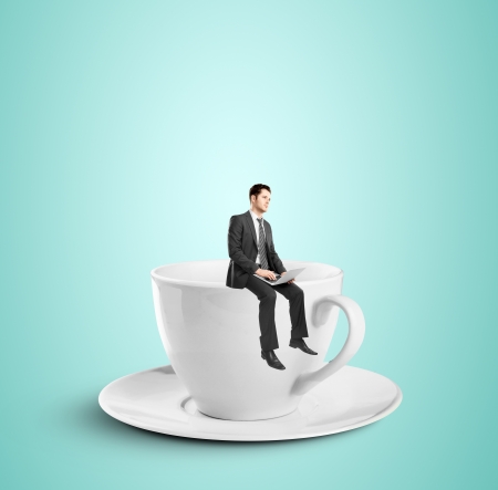 businessman sitting with notebook on cupの写真素材